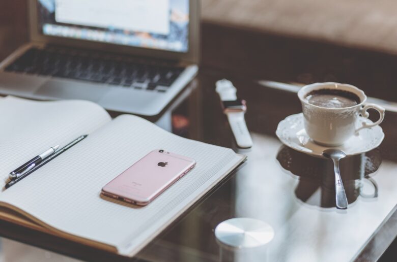 Notes z telefonem i kawą na biurku