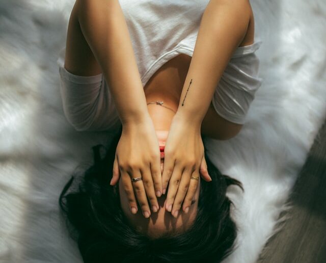 Kobieta chowająca twarz w dłonie