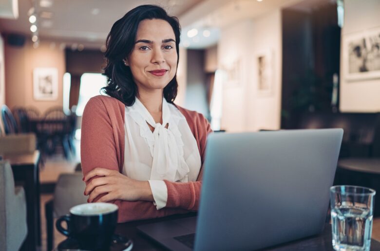 Kobieta w kawą i laptopem (Foto. Canva Pro)