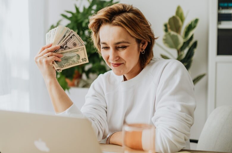 Kobieta z banknotami w ręku (Foto. Canva Pro)