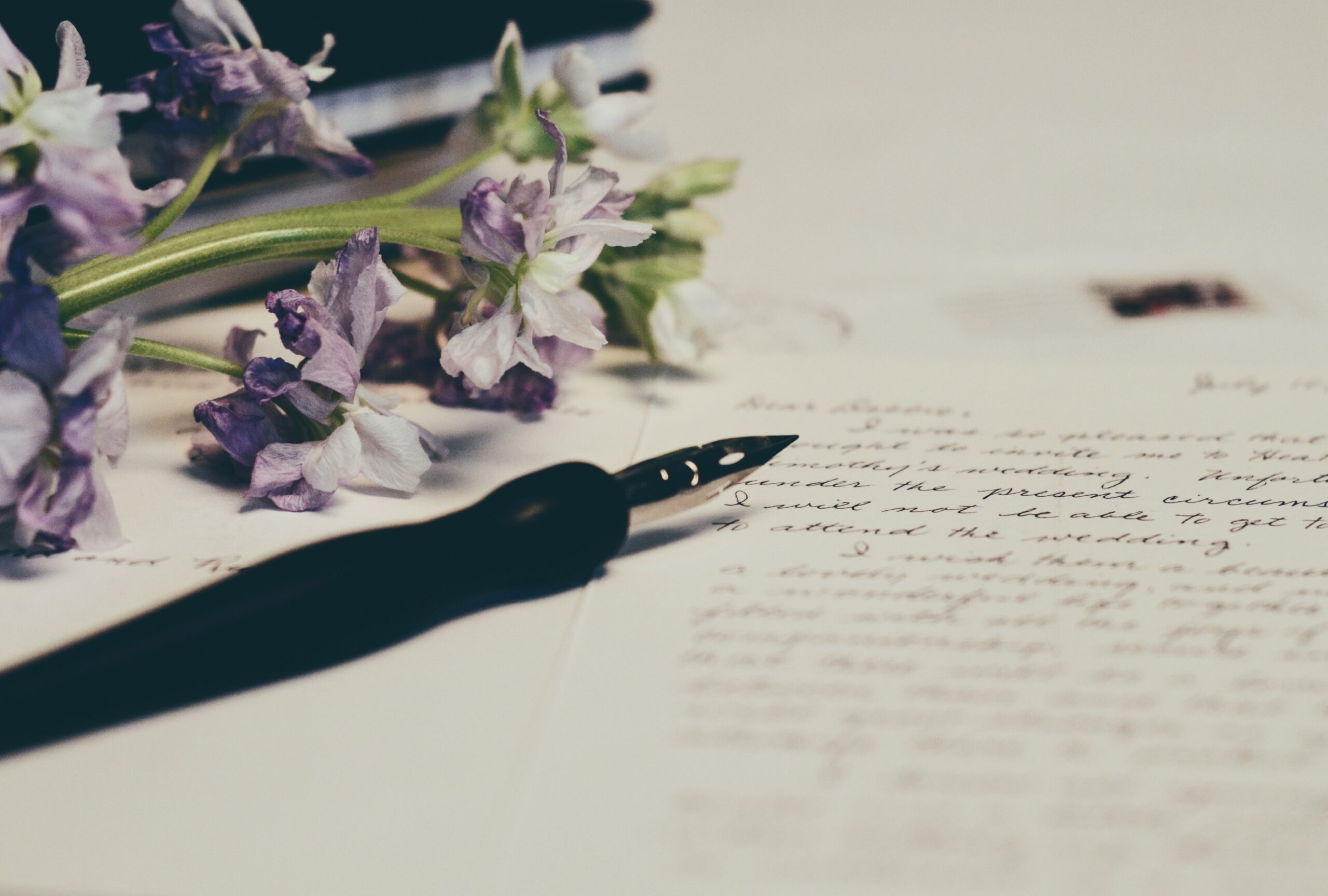 list napisany na papierze, wieczne pióro oraz kwiaty