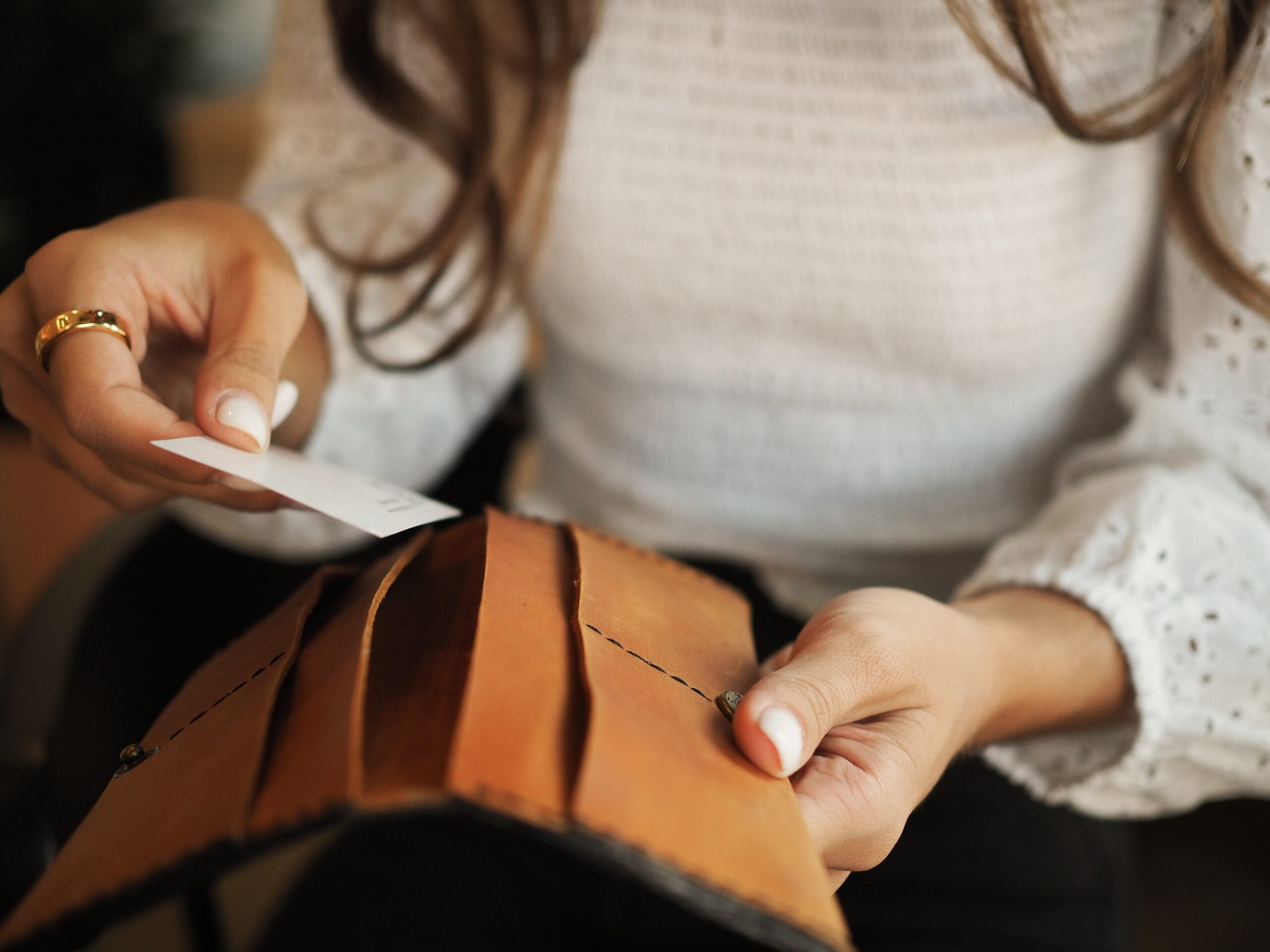 Kobieta wkładająca kartę płatniczą do portfela