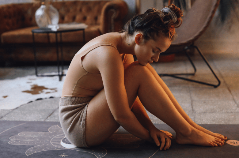 Kobieta siedząca na macie do jogi