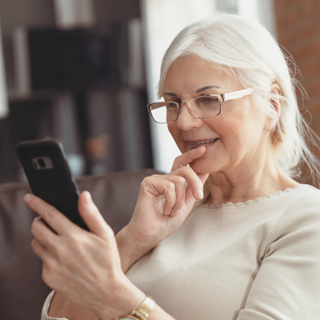 Kobieta po 60. roku życia z telefonem w ręku