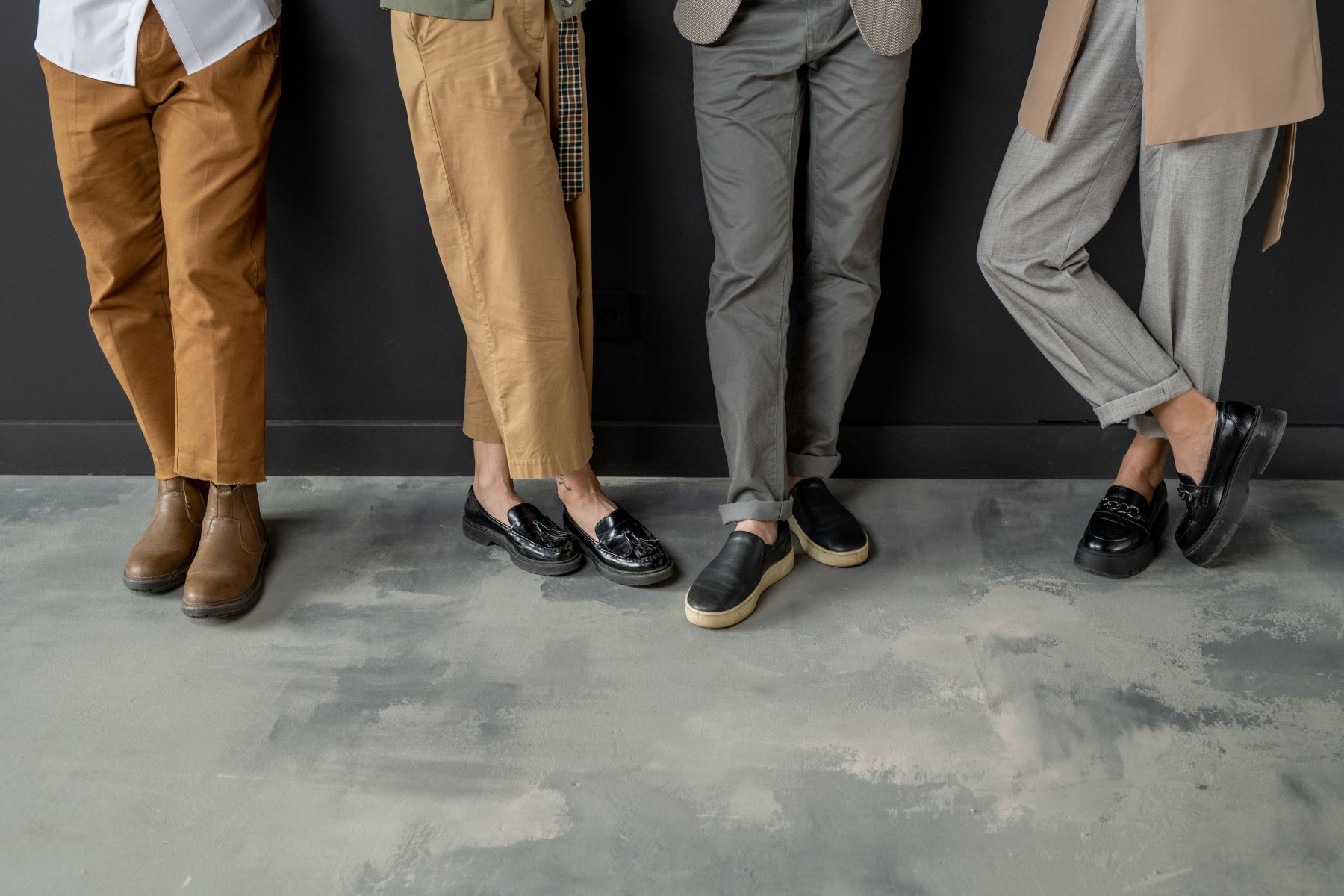 Zdjęcie nóg kilku osób w różnych eleganckich butach (advertorial)