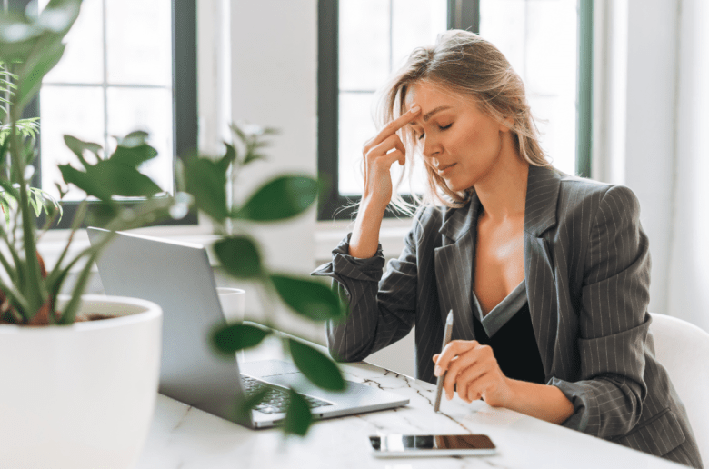 Dlaczego kobiety są dyskryminowane? Na zdjęciu: Zmartwiona kobieta przy biurku w pracy.