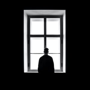 Chłopak stojący samotnie przy oknie