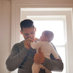 Mężczyzna opiekujący się niemowlakiem (Foto. Canva Pro)