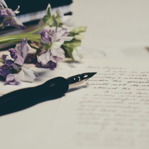 list napisany na papierze, wieczne pióro oraz kwiaty